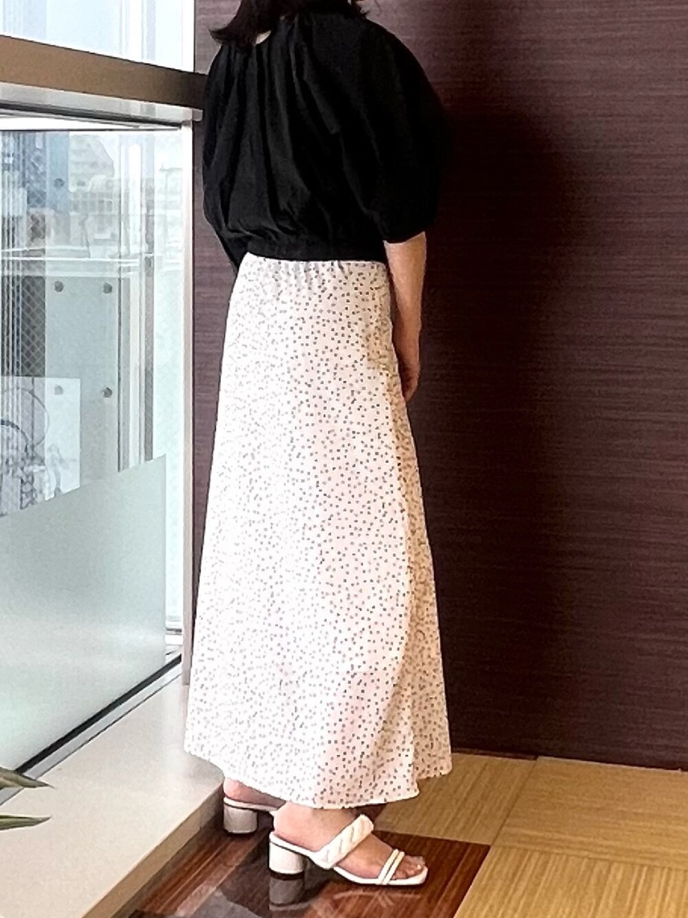 ブラック系のシャツ/ブラウス、ホワイト系のスカート、ホワイト系のサンダルを着用したレディースの夏コーディネートの5枚目の写真