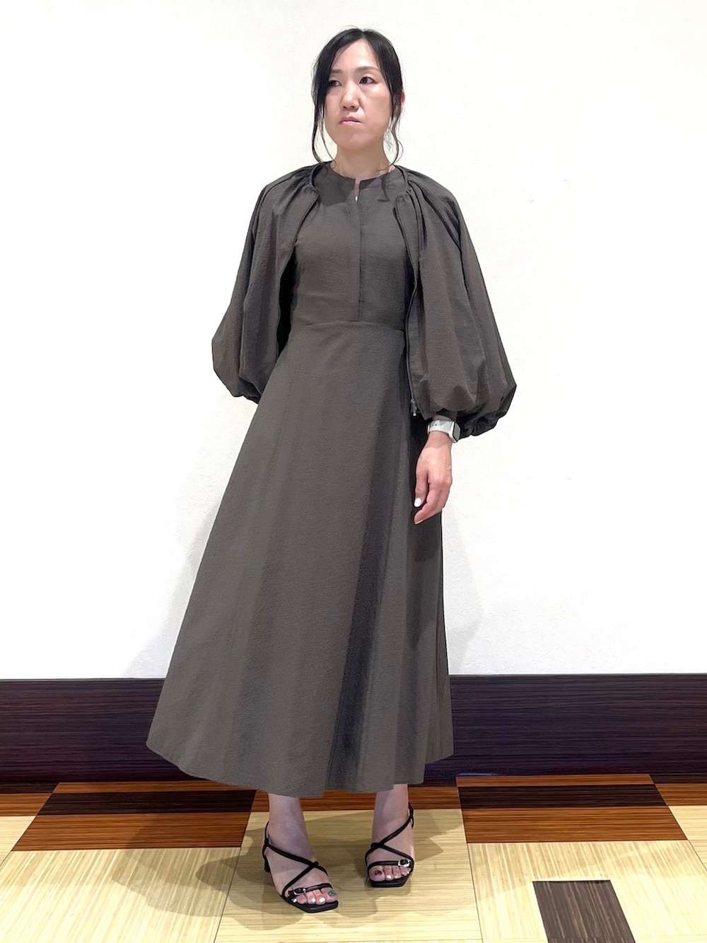 ブラウン系のワンピース、ブラウン系のブルゾン、ブラック系のサンダルを着用したレディースの秋コーディネートの3枚目の写真