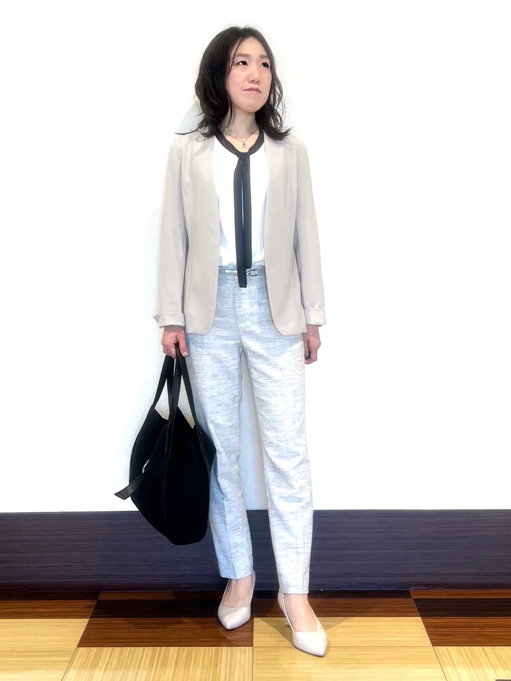 ブラック系のスーツジャケット、ホワイト系のシャツ/ブラウス、ブラック系のその他パンツを着用したレディースの春コーディネートの3枚目の写真