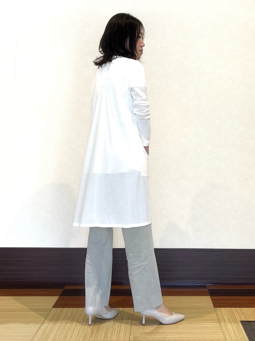 ホワイト系のシャツ/ブラウス、ホワイト系のカーディガン/ボレロ、グレー系のスーツパンツを着用したレディースの春コーディネートの5枚目の写真