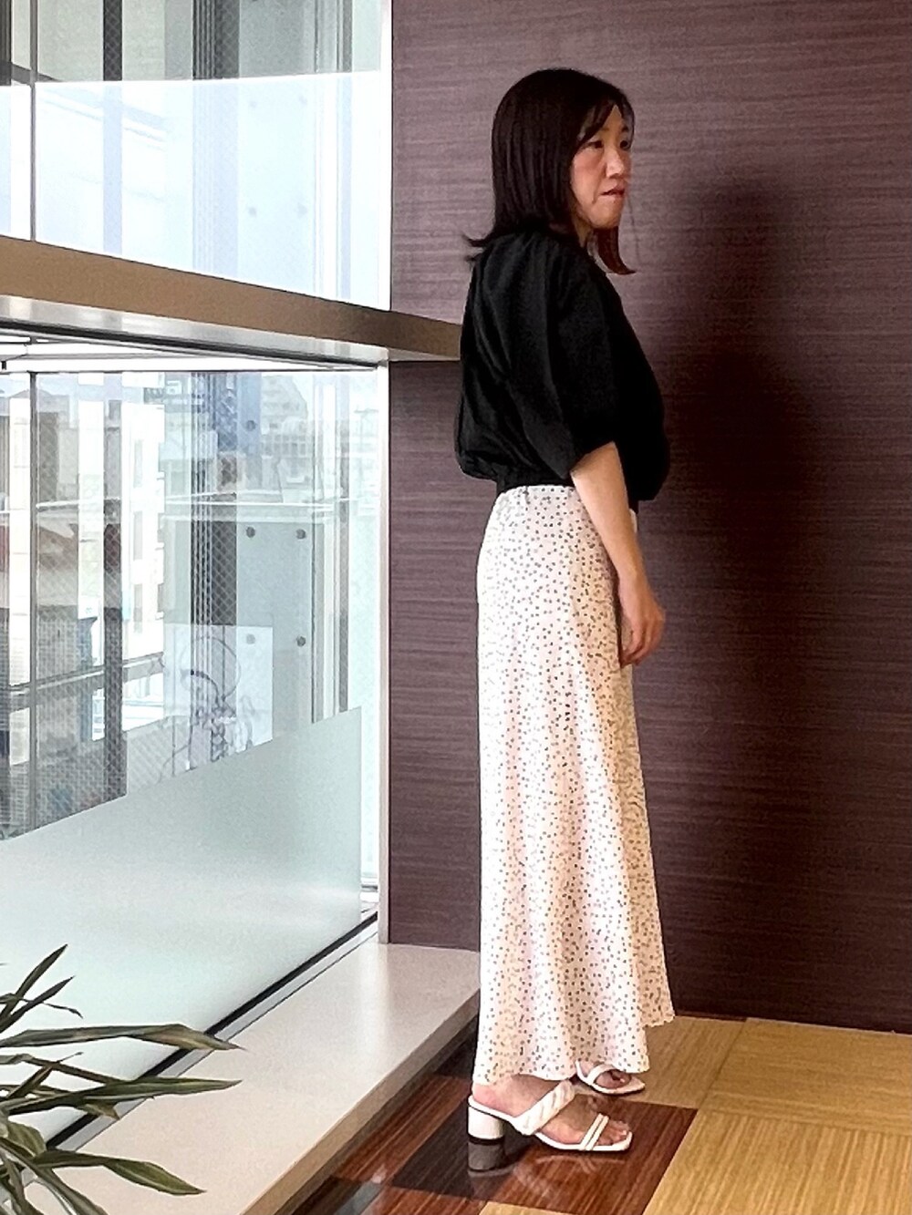 ブラック系のシャツ/ブラウス、ホワイト系のスカート、ホワイト系のサンダルを着用したレディースの夏コーディネートの4枚目の写真