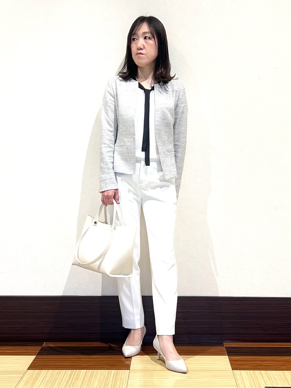 ブラック系のノーカラージャケット、ホワイト系のシャツ/ブラウス、ホワイト系のその他パンツを着用したレディースの春コーディネートの2枚目の写真