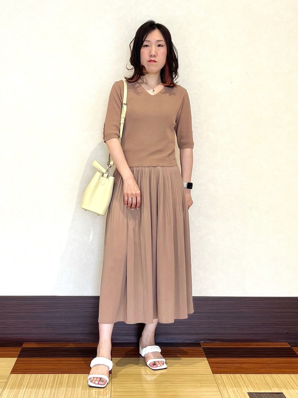 ベージュ系のワンピース、イエロー系のショルダーバッグ、ホワイト系のサンダルを着用したレディースの夏コーディネートの2枚目の写真