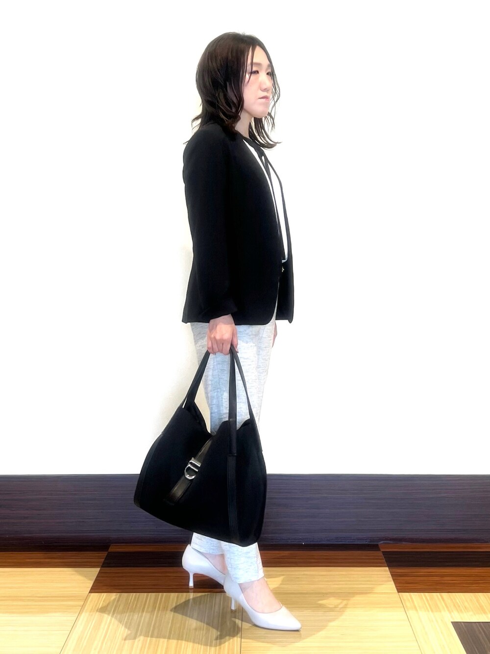 ブラック系のスーツジャケット、ホワイト系のシャツ/ブラウス、ブラック系のその他パンツを着用したレディースの春コーディネートの4枚目の写真