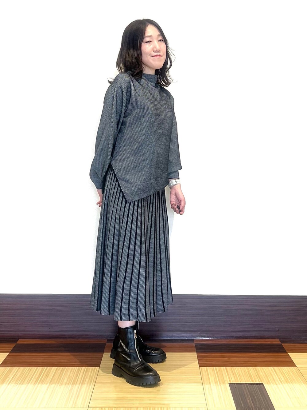 ブラック系のニット/セーター、ブラック系のスカート、ブラック系のブーツを着用したレディースの秋コーディネートの3枚目の写真