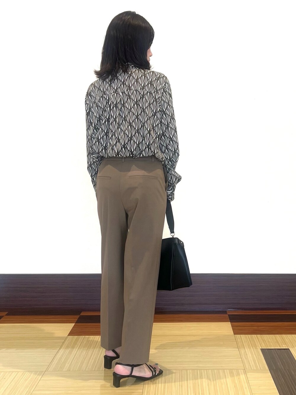 ブラウン系のシャツ/ブラウス、ブラウン系のその他パンツ、ブラック系のハンドバッグを着用したレディースの秋コーディネートの5枚目の写真