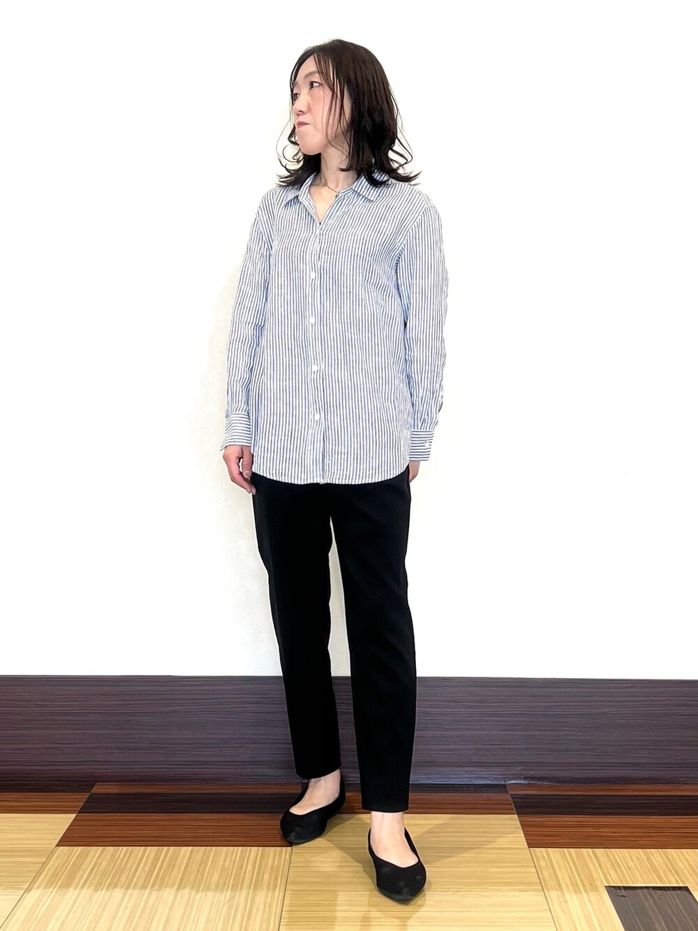 ホワイト系のシャツ/ブラウス、ブラック系のスーツパンツ、ブラック系のパンプスを着用したレディースの春コーディネートの4枚目の写真