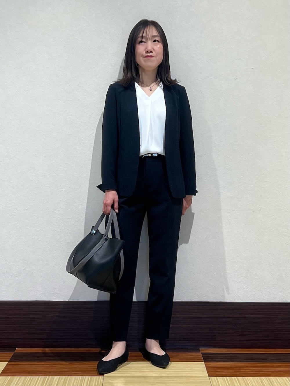 ブルー系のスーツジャケット、ホワイト系のシャツ/ブラウス、ブルー系のスーツパンツを着用したレディースの春コーディネートの2枚目の写真