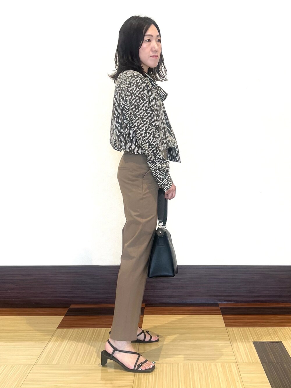 ブラウン系のシャツ/ブラウス、ブラウン系のその他パンツ、ブラック系のハンドバッグを着用したレディースの秋コーディネートの4枚目の写真