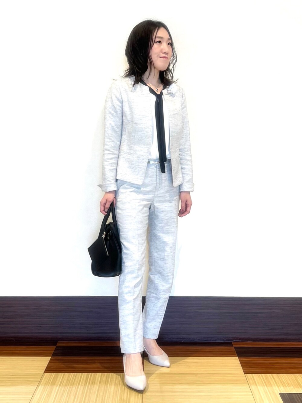 ブラック系のノーカラージャケット、ホワイト系のシャツ/ブラウス、ブラック系のその他パンツを着用したレディースの春コーディネートの2枚目の写真