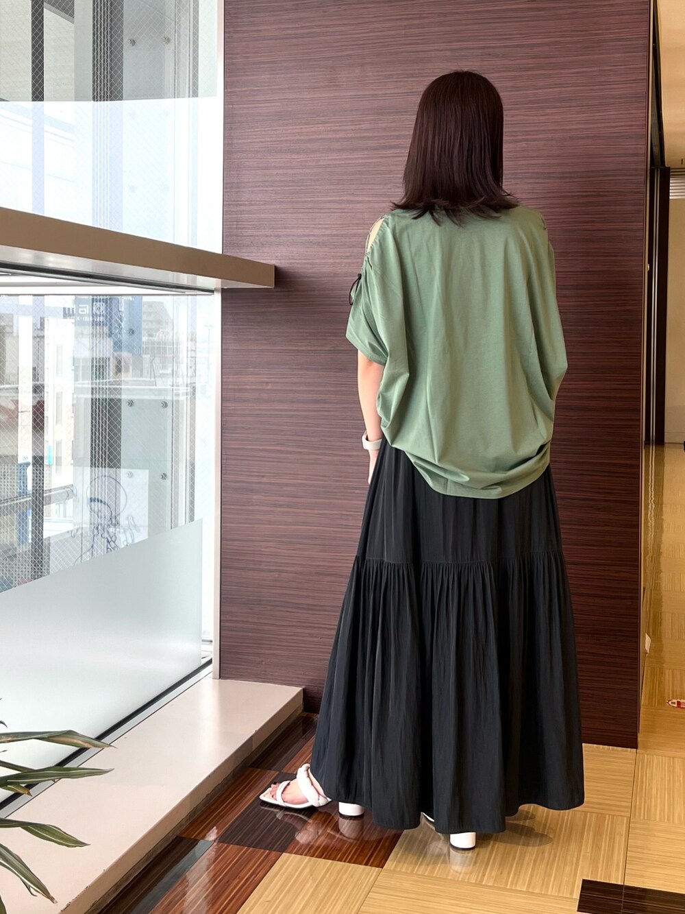 グリーン系のTシャツ/カットソー、グレー系のスカート、ホワイト系のサンダルを着用したレディースの夏コーディネートの5枚目の写真