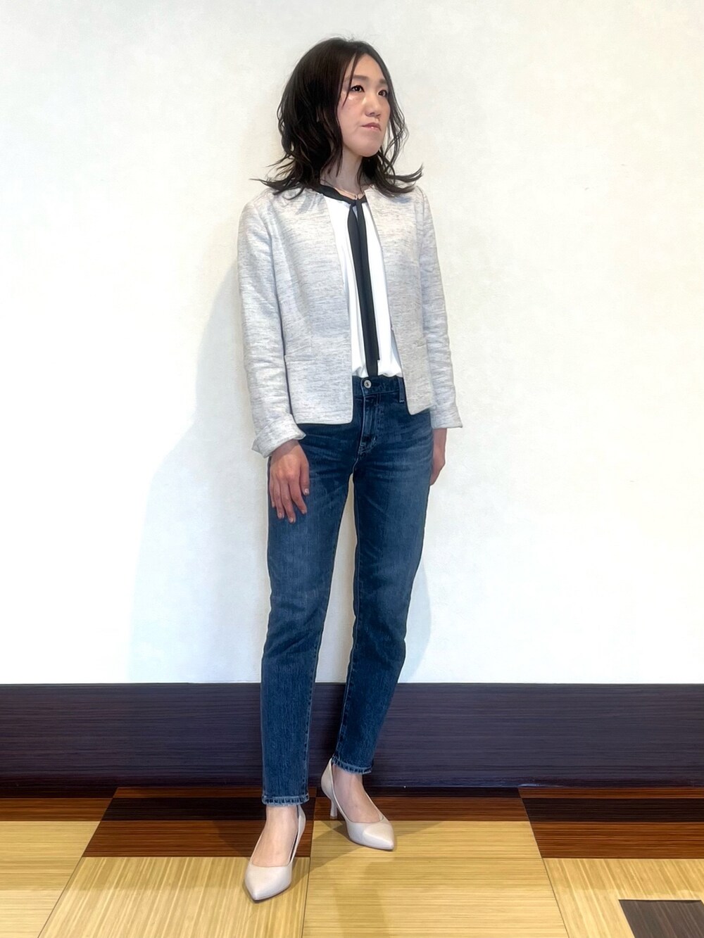 ブラック系のノーカラージャケット、ホワイト系のシャツ/ブラウス、ブルー系のデニムパンツを着用したレディースの春コーディネートの3枚目の写真