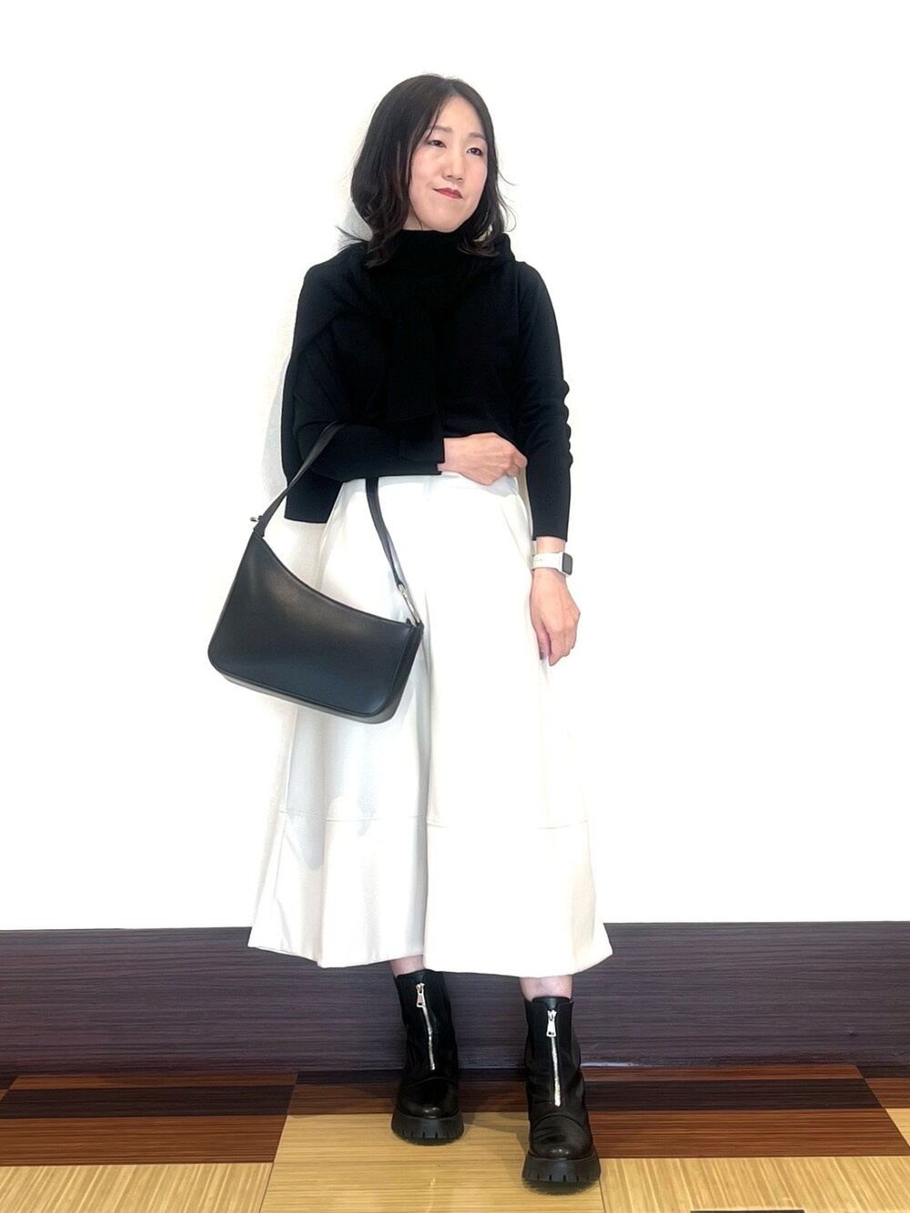 ブラック系のニット/セーター、ブラック系のニット/セーター、ブラック系のブーツを着用したレディースの秋コーディネートの2枚目の写真