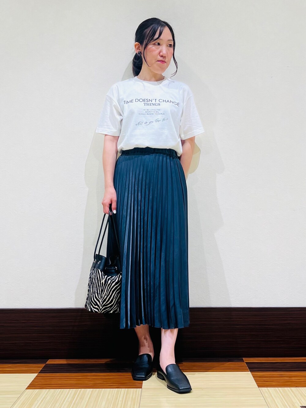 ブラック系のシャツ/ブラウス、ホワイト系のTシャツ/カットソー、グレー系のスカートを着用したレディースの秋コーディネートの3枚目の写真