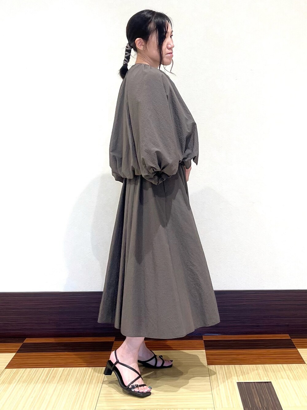 ブラウン系のワンピース、ブラウン系のブルゾン、ブラック系のサンダルを着用したレディースの秋コーディネートの4枚目の写真