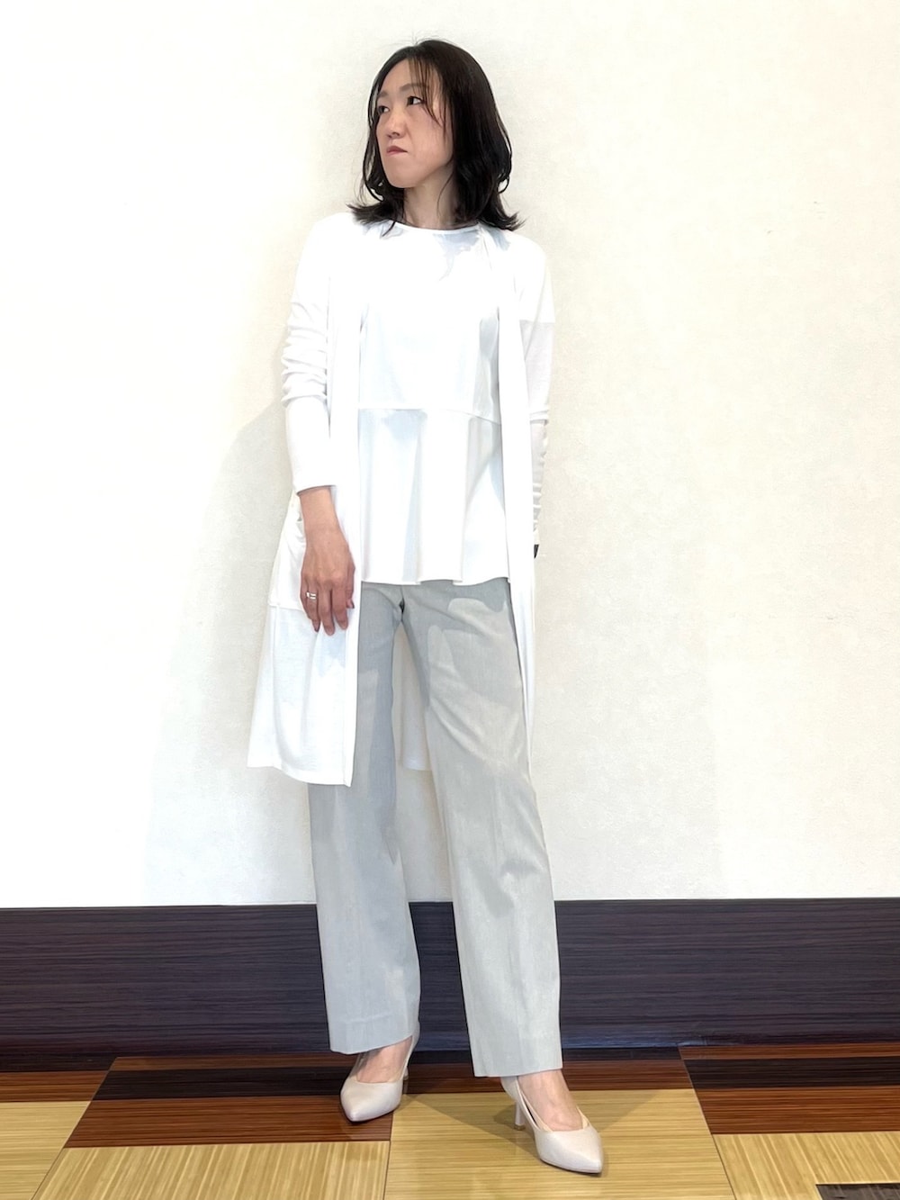 ホワイト系のシャツ/ブラウス、ホワイト系のカーディガン/ボレロ、グレー系のスーツパンツを着用したレディースの春コーディネートの3枚目の写真