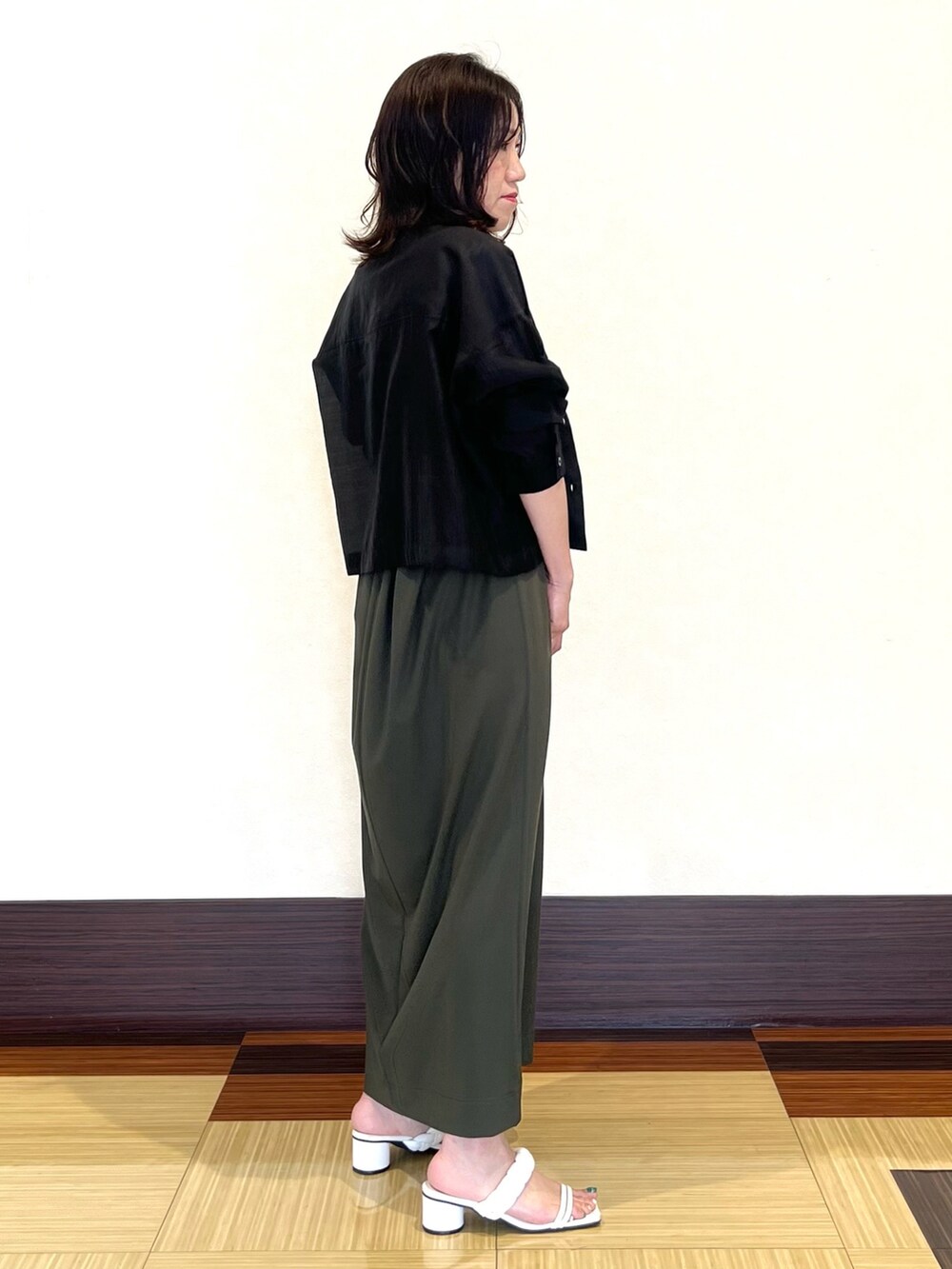 ブラック系のシャツ/ブラウス、グリーン系のワンピース、ホワイト系のサンダルを着用したレディースの夏コーディネートの4枚目の写真