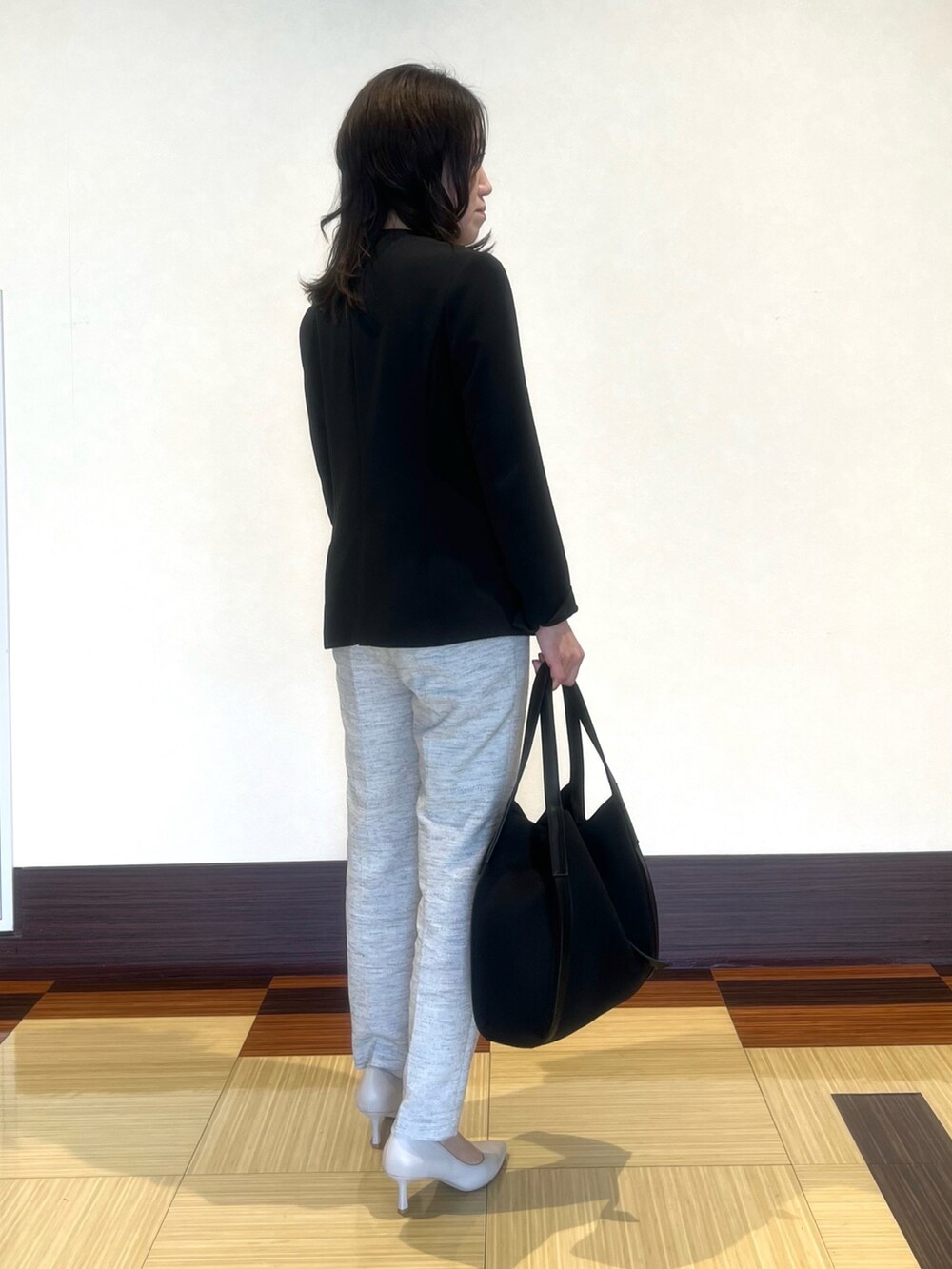 ブラック系のスーツジャケット、ホワイト系のシャツ/ブラウス、ブラック系のその他パンツを着用したレディースの春コーディネートの5枚目の写真