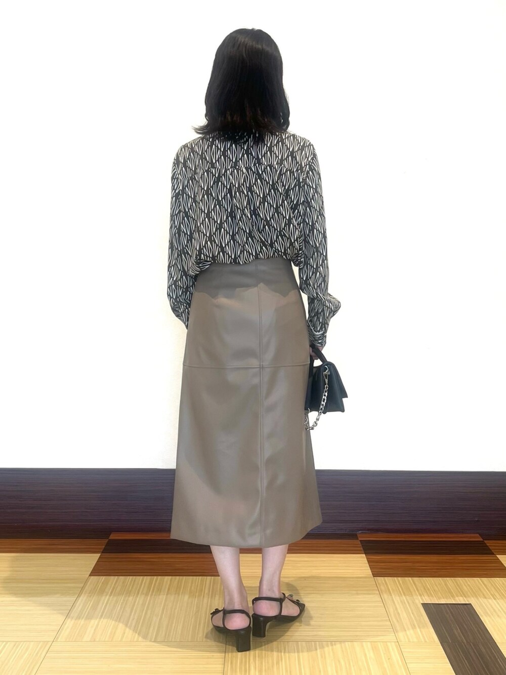 ブラウン系のシャツ/ブラウス、ベージュ系のスカート、ブラック系のサンダルを着用したレディースの秋コーディネートの5枚目の写真