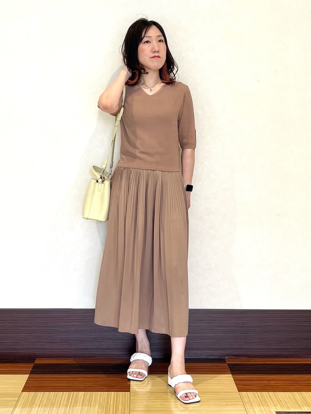 ベージュ系のワンピース、イエロー系のショルダーバッグ、ホワイト系のサンダルを着用したレディースの夏コーディネートの3枚目の写真