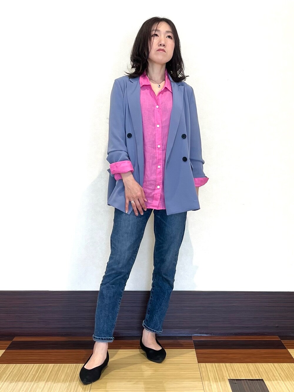 ピンク系のシャツ/ブラウス、ブルー系のスーツジャケット、ブラック系のパンプスを着用したレディースの春コーディネートの3枚目の写真