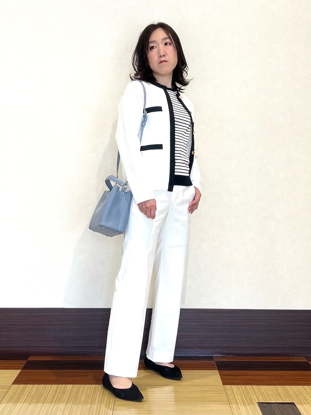ホワイト系のカーディガン/ボレロ、ホワイト系のニット/セーター、ホワイト系のスーツパンツを着用したレディースの春コーディネートの2枚目の写真
