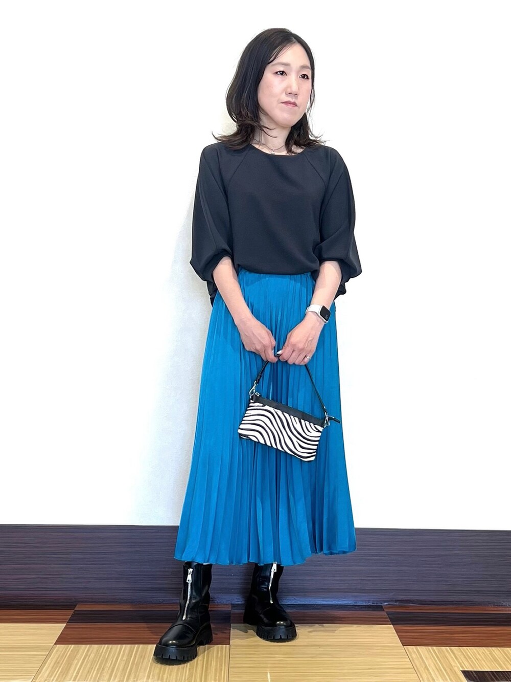 グレー系のTシャツ/カットソー、ブラック系のショルダーバッグ、ブルー系のスカートを着用したレディースの秋コーディネートの4枚目の写真
