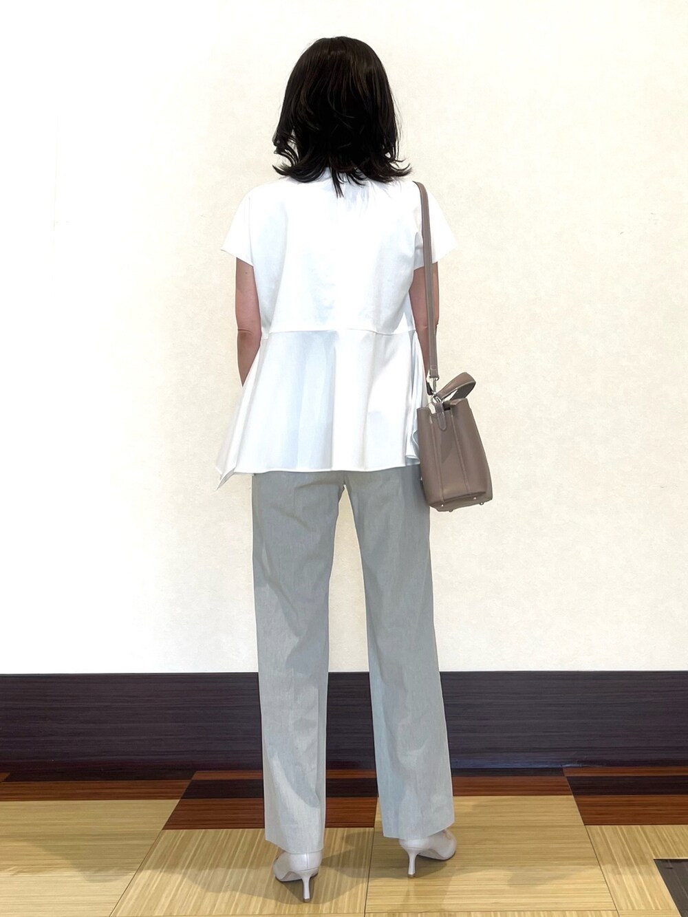 グレー系のスーツジャケット、ホワイト系のシャツ/ブラウス、グレー系のスーツパンツを着用したレディースの春コーディネートの5枚目の写真