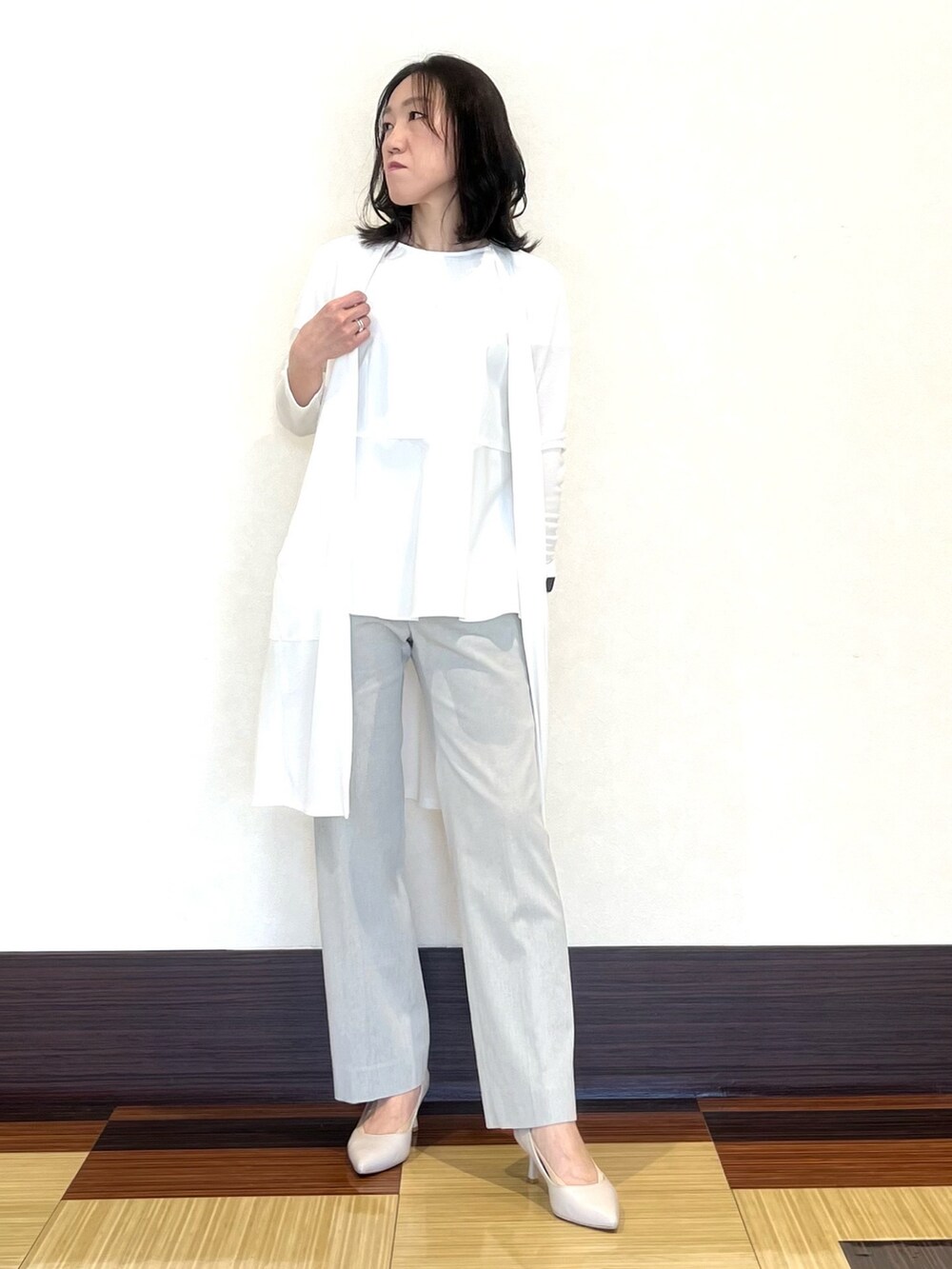 ホワイト系のシャツ/ブラウス、ホワイト系のカーディガン/ボレロ、グレー系のスーツパンツを着用したレディースの春コーディネートの4枚目の写真