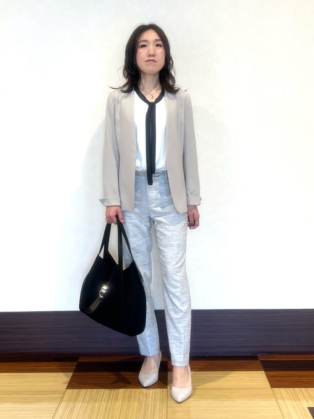 ブラック系のスーツジャケット、ホワイト系のシャツ/ブラウス、ブラック系のその他パンツを着用したレディースの春コーディネートの2枚目の写真