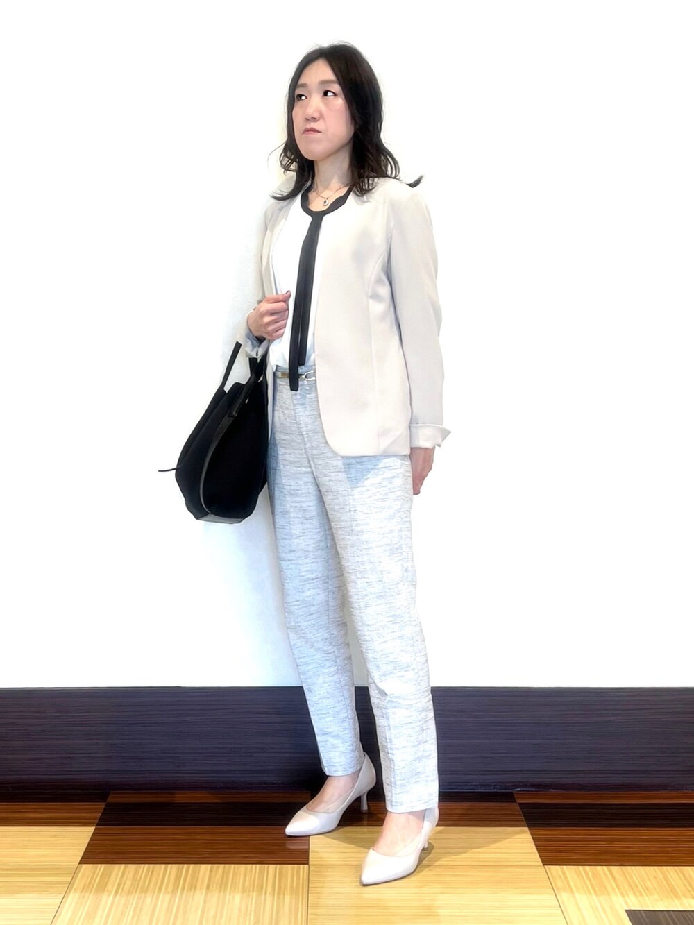 ブラック系のスーツジャケット、ホワイト系のシャツ/ブラウス、ブラック系のその他パンツを着用したレディースの春コーディネートの4枚目の写真