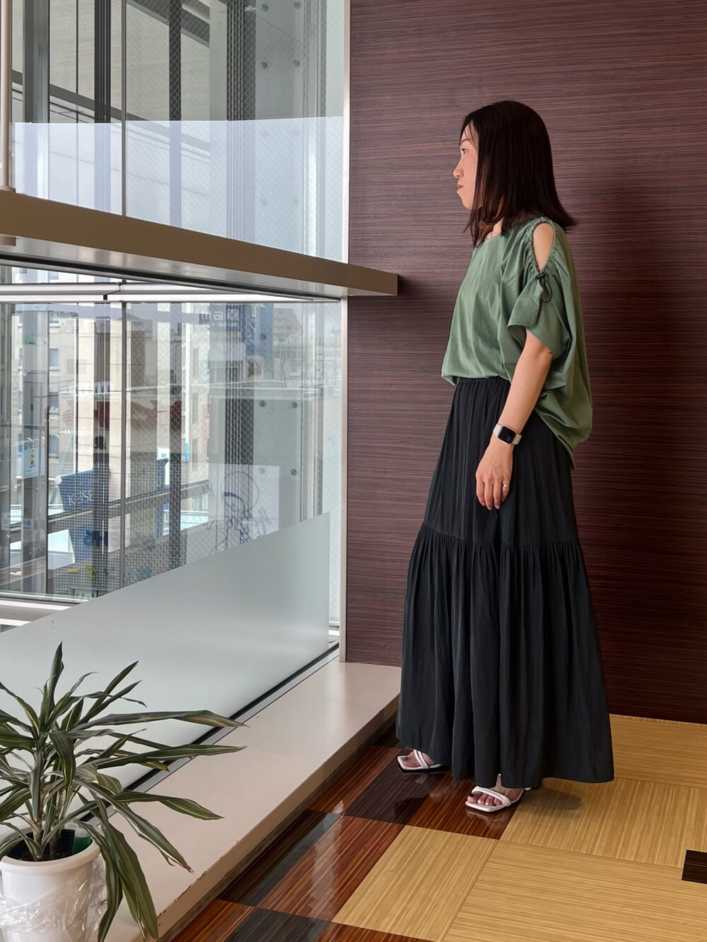 グリーン系のTシャツ/カットソー、グレー系のスカート、ホワイト系のサンダルを着用したレディースの夏コーディネートの4枚目の写真