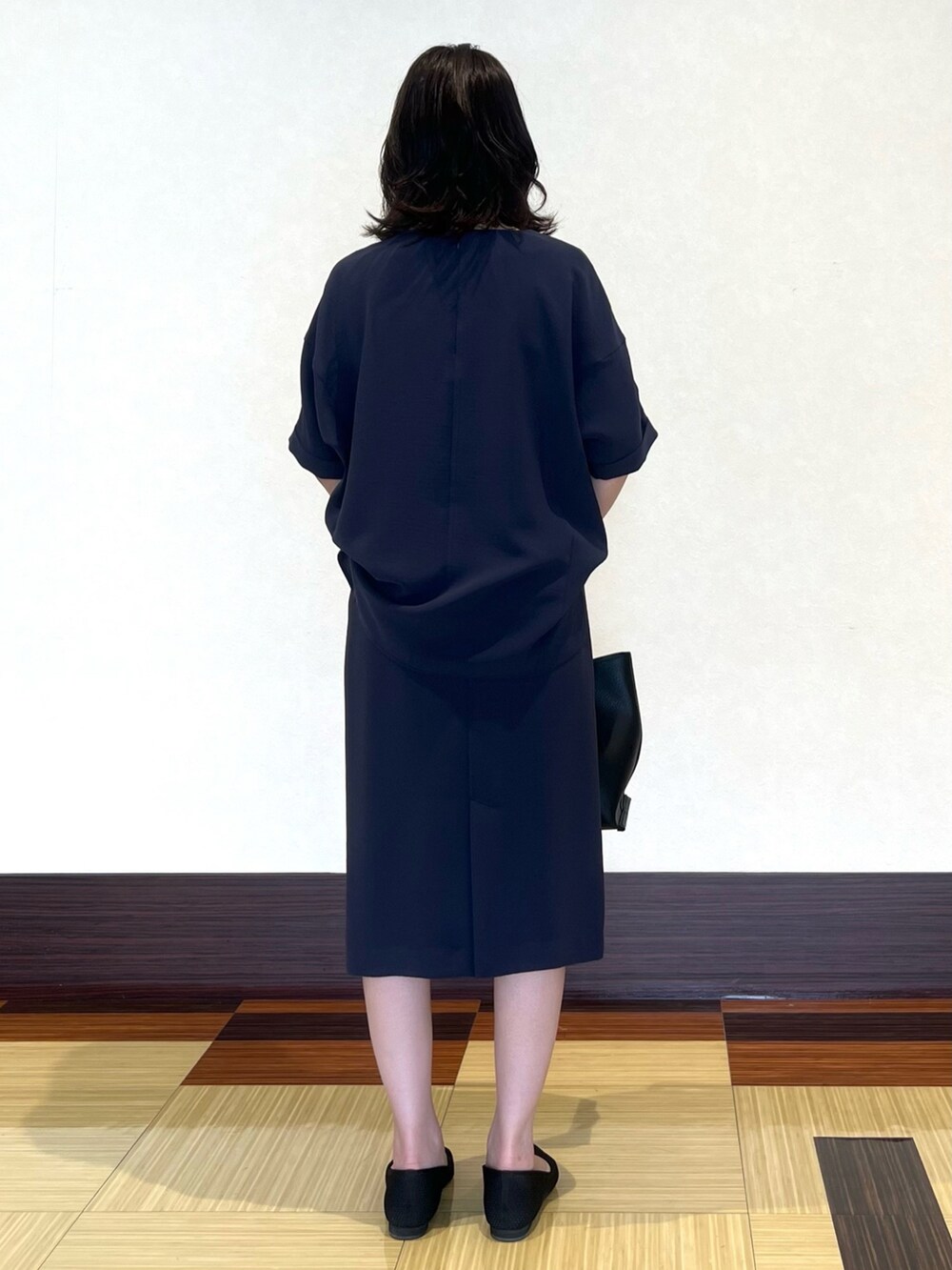 グレー系のシャツ/ブラウス、グレー系のスカート、ブラック系のパンプスを着用したレディースの春コーディネートの5枚目の写真