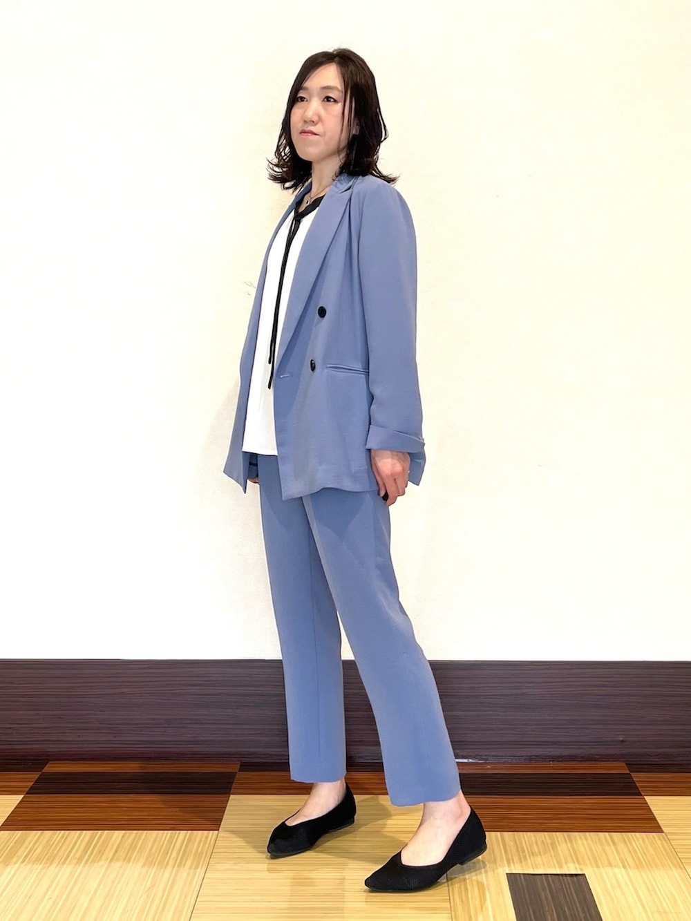 ブルー系のスーツジャケット、ホワイト系のシャツ/ブラウス、ブルー系のスーツパンツを着用したレディースの春コーディネートの3枚目の写真
