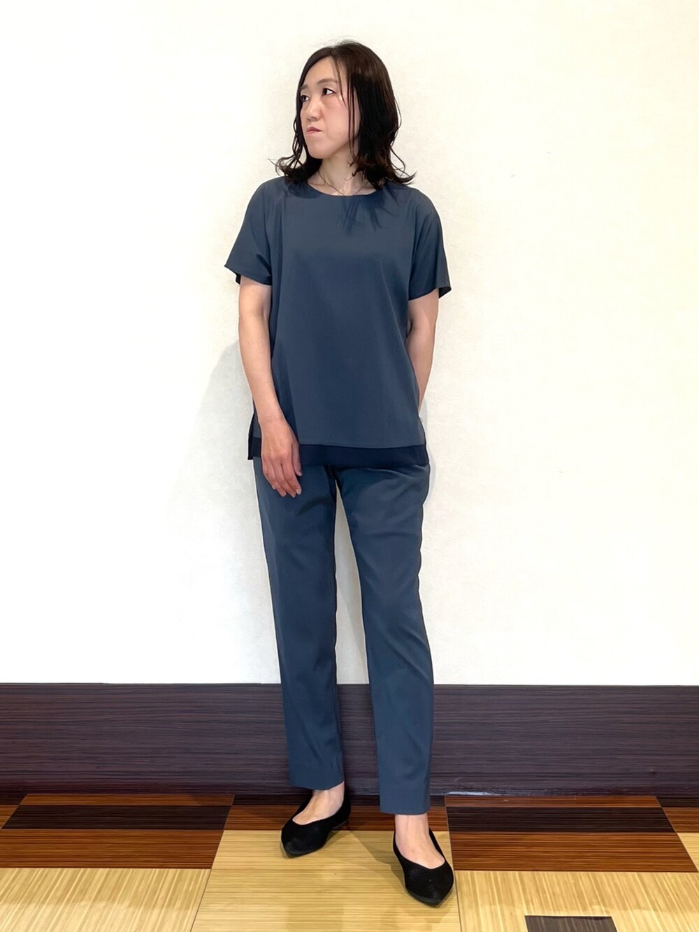 グレー系のシャツ/ブラウス、グレー系のその他パンツ、ブラック系のパンプスを着用したレディースの春コーディネートの2枚目の写真