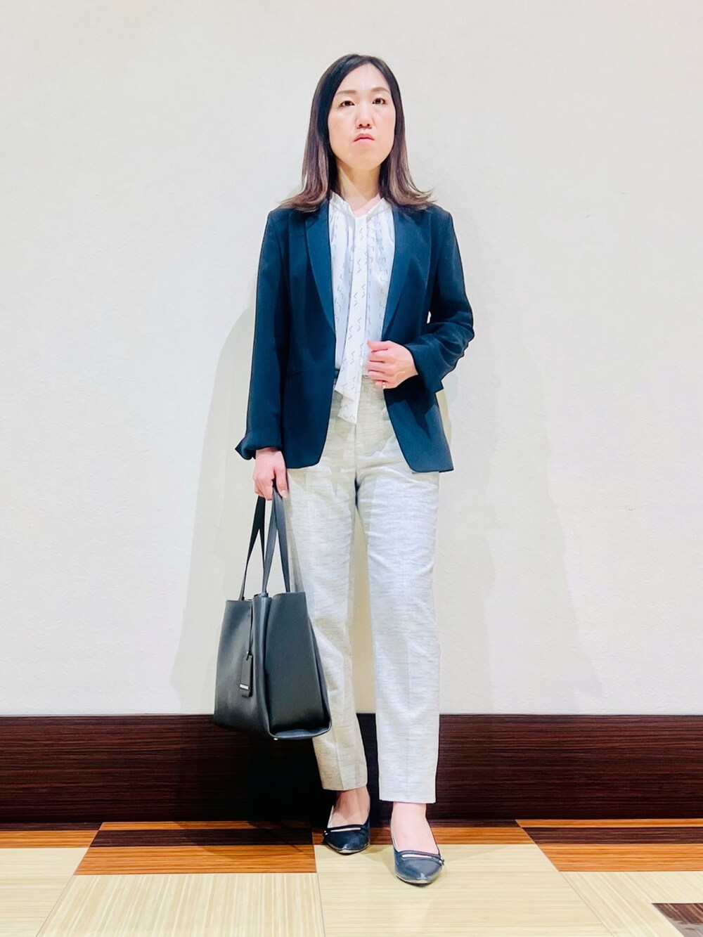 ブルー系のスーツジャケット、グレー系のシャツ/ブラウス、ブラック系のスーツパンツを着用したレディースの春コーディネートの2枚目の写真
