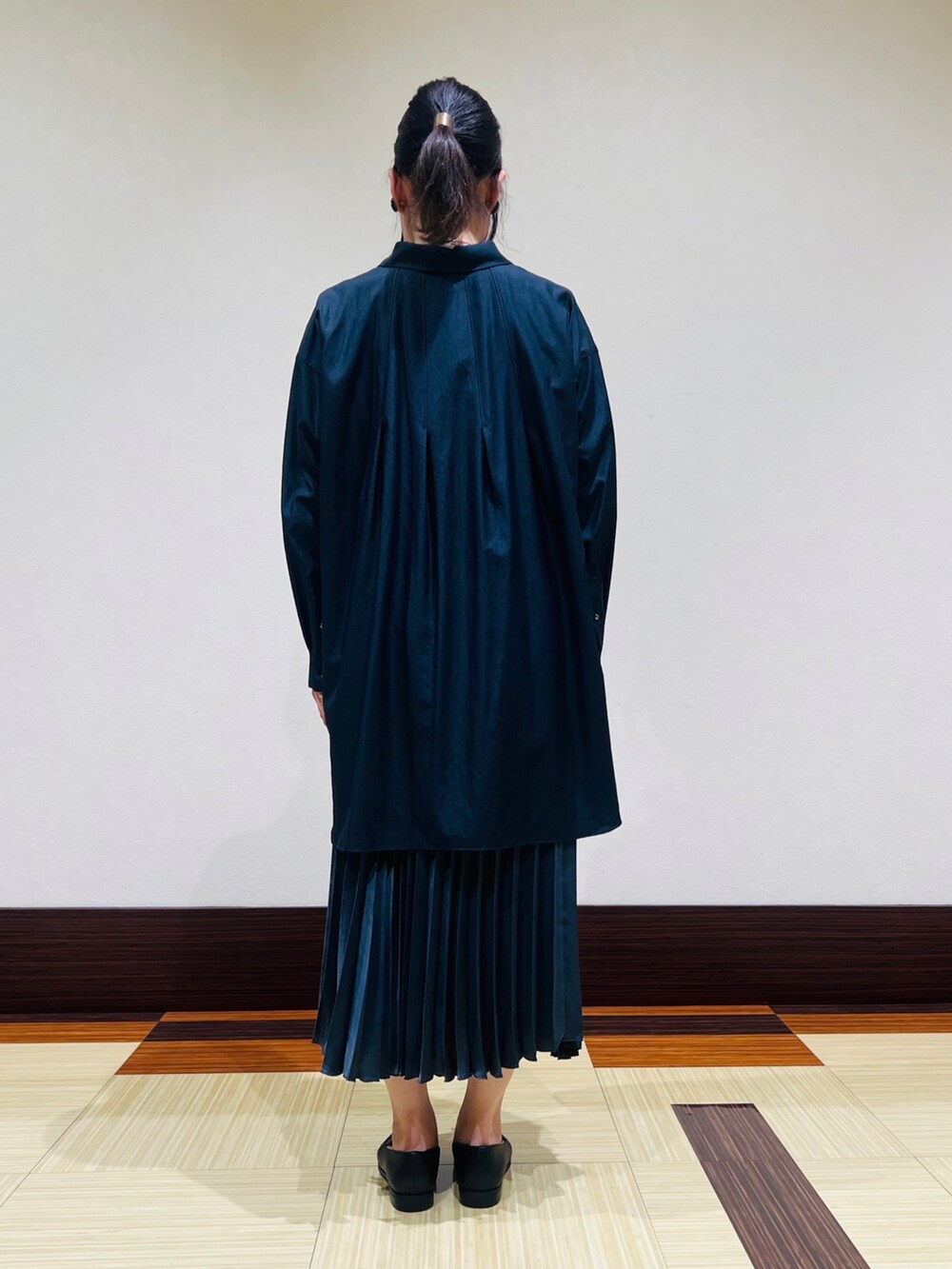 ブラック系のシャツ/ブラウス、ホワイト系のTシャツ/カットソー、グレー系のスカートを着用したレディースの秋コーディネートの5枚目の写真