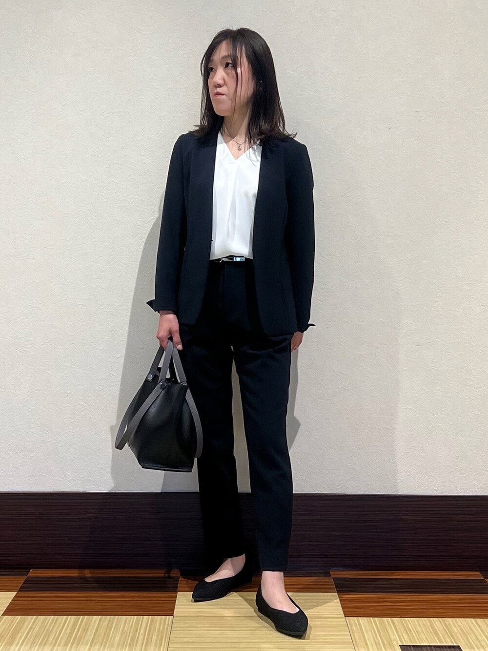 ブルー系のスーツジャケット、ホワイト系のシャツ/ブラウス、ブルー系のスーツパンツを着用したレディースの春コーディネートの3枚目の写真