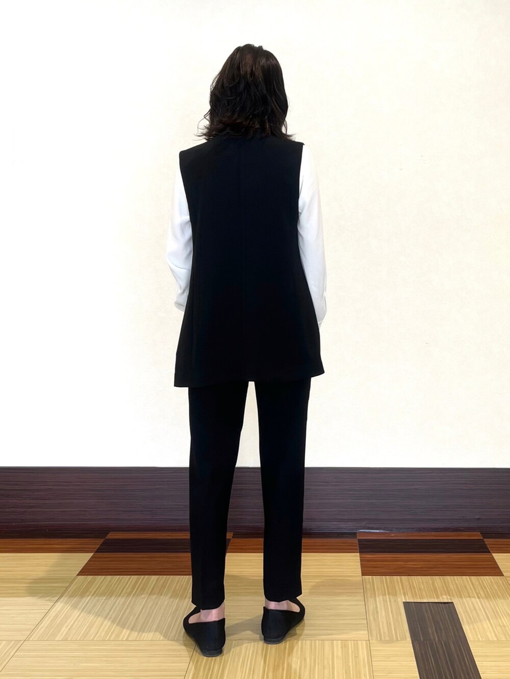 ホワイト系のシャツ/ブラウス、ブラック系のベスト、ブラック系のスーツパンツを着用したレディースの春コーディネートの5枚目の写真
