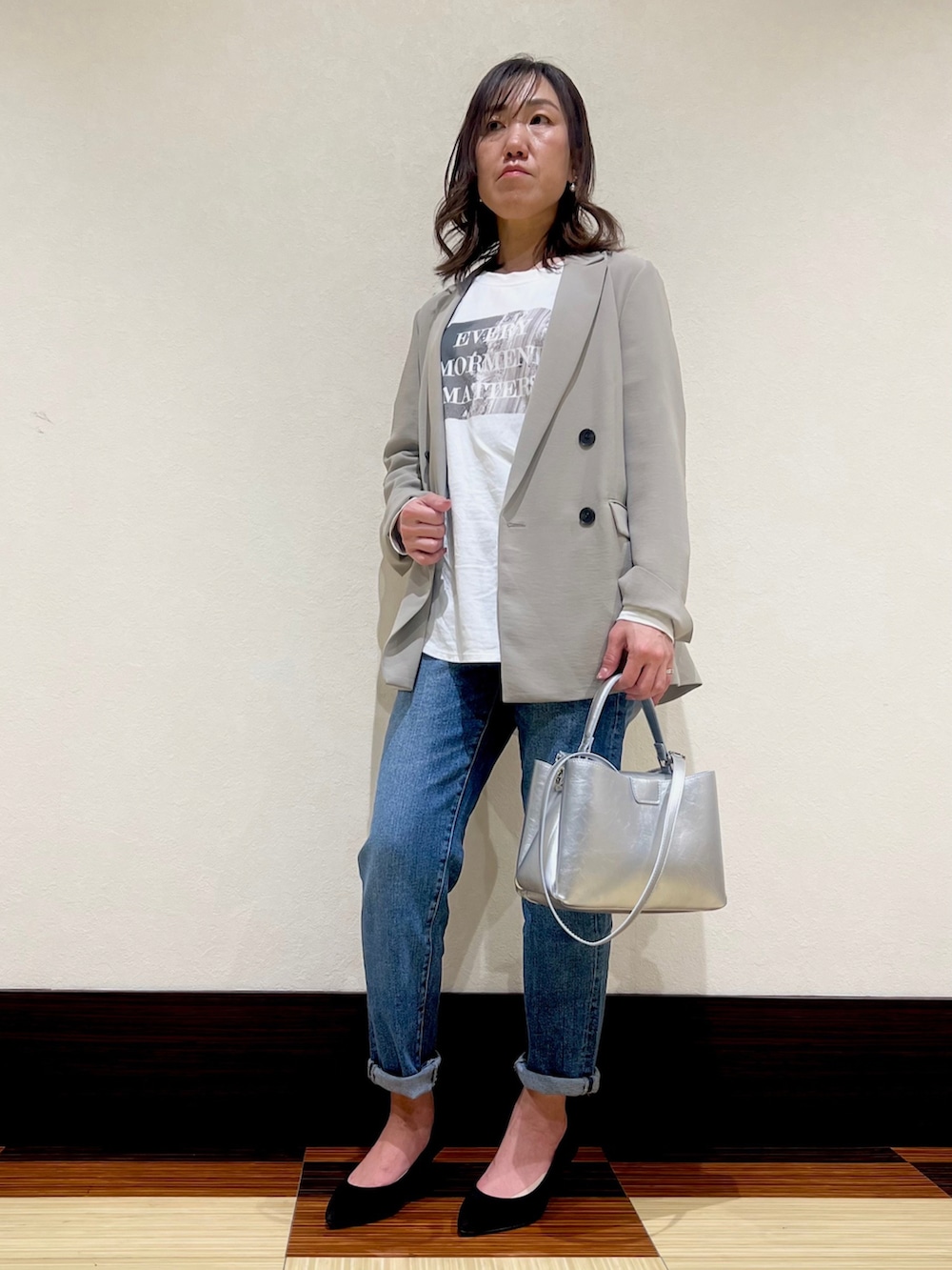 ベージュ系のスーツジャケット、ホワイト系のTシャツ/カットソー、ブルー系のデニムパンツを着用したレディースの春コーディネートの2枚目の写真