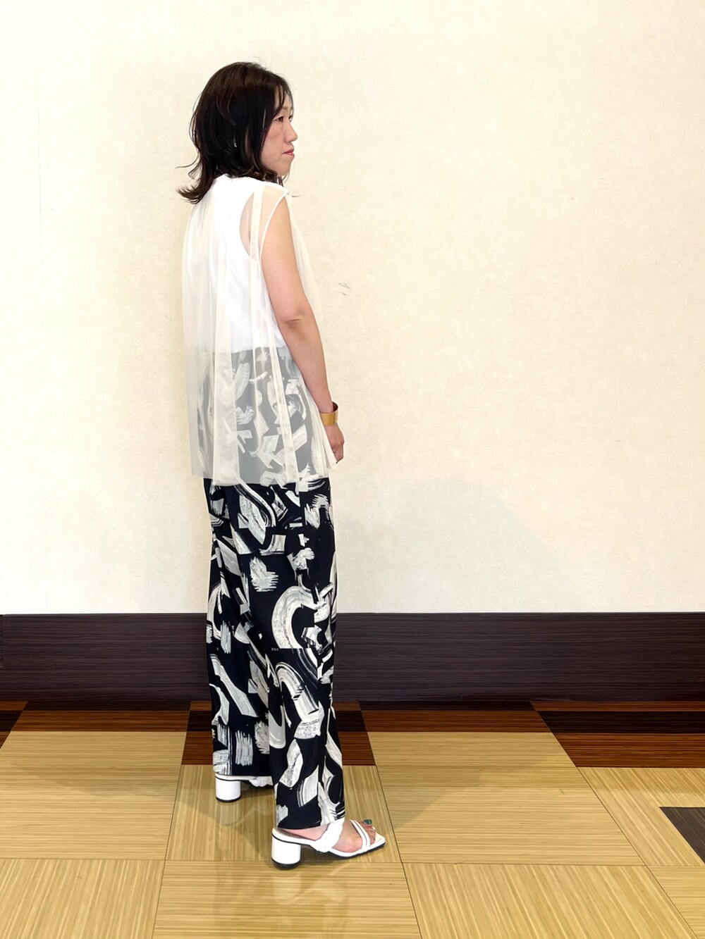 ホワイト系のTシャツ/カットソー、ブラック系のその他パンツ、ホワイト系のサンダルを着用したレディースの夏コーディネートの2枚目の写真