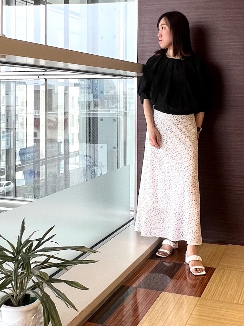 ブラック系のシャツ/ブラウス、ホワイト系のスカート、ホワイト系のサンダルを着用したレディースの夏コーディネートの2枚目の写真