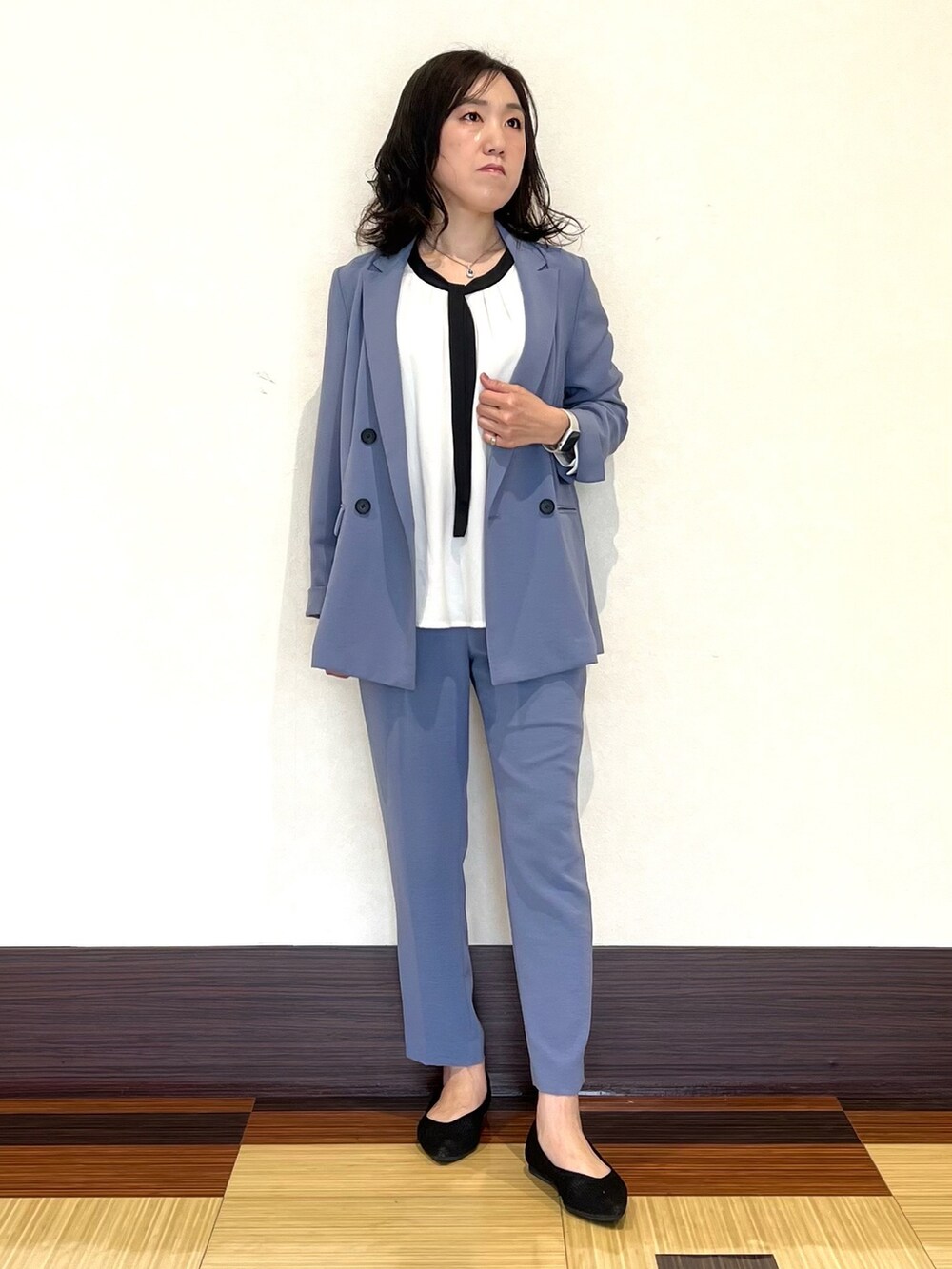 ブルー系のスーツジャケット、ホワイト系のシャツ/ブラウス、ブルー系のスーツパンツを着用したレディースの春コーディネートの2枚目の写真