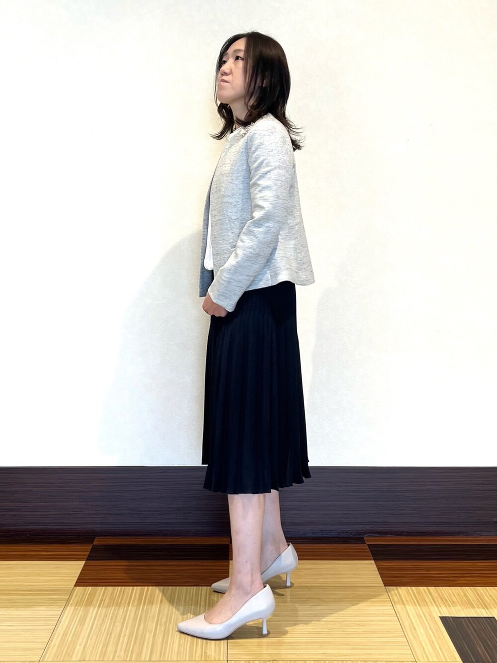 ホワイト系のシャツ/ブラウス、ブラック系のノーカラージャケット、ブルー系のスカートを着用したレディースの冬コーディネートの4枚目の写真