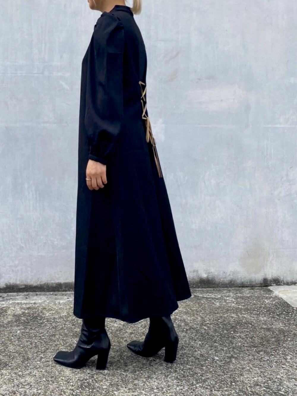 ブラック系のワンピースを着用したレディースの冬コーディネートの2枚目の写真