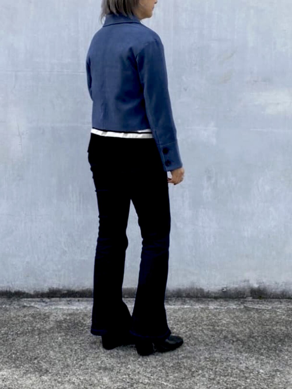 ブルー系のテーラードジャケット、ブラック系のニット/セーター、ブルー系のデニムパンツを着用したレディースの冬コーディネートの2枚目の写真