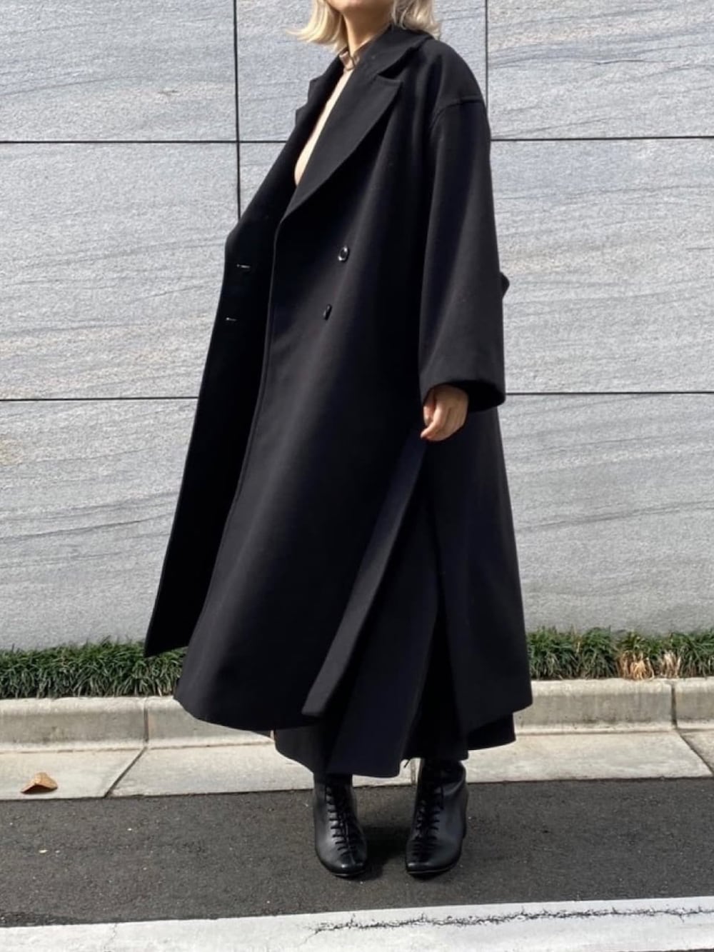 ベージュ系のワンピース、ブラック系のステンカラーコートを着用したレディースの冬コーディネートの2枚目の写真