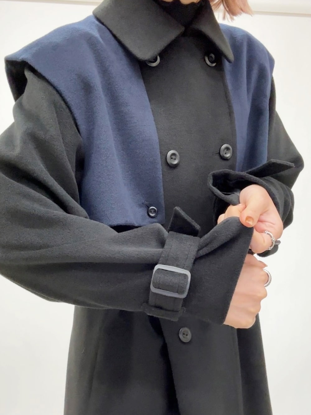 ブラック系のチェスターコートを着用したレディースの冬コーディネートの3枚目の写真