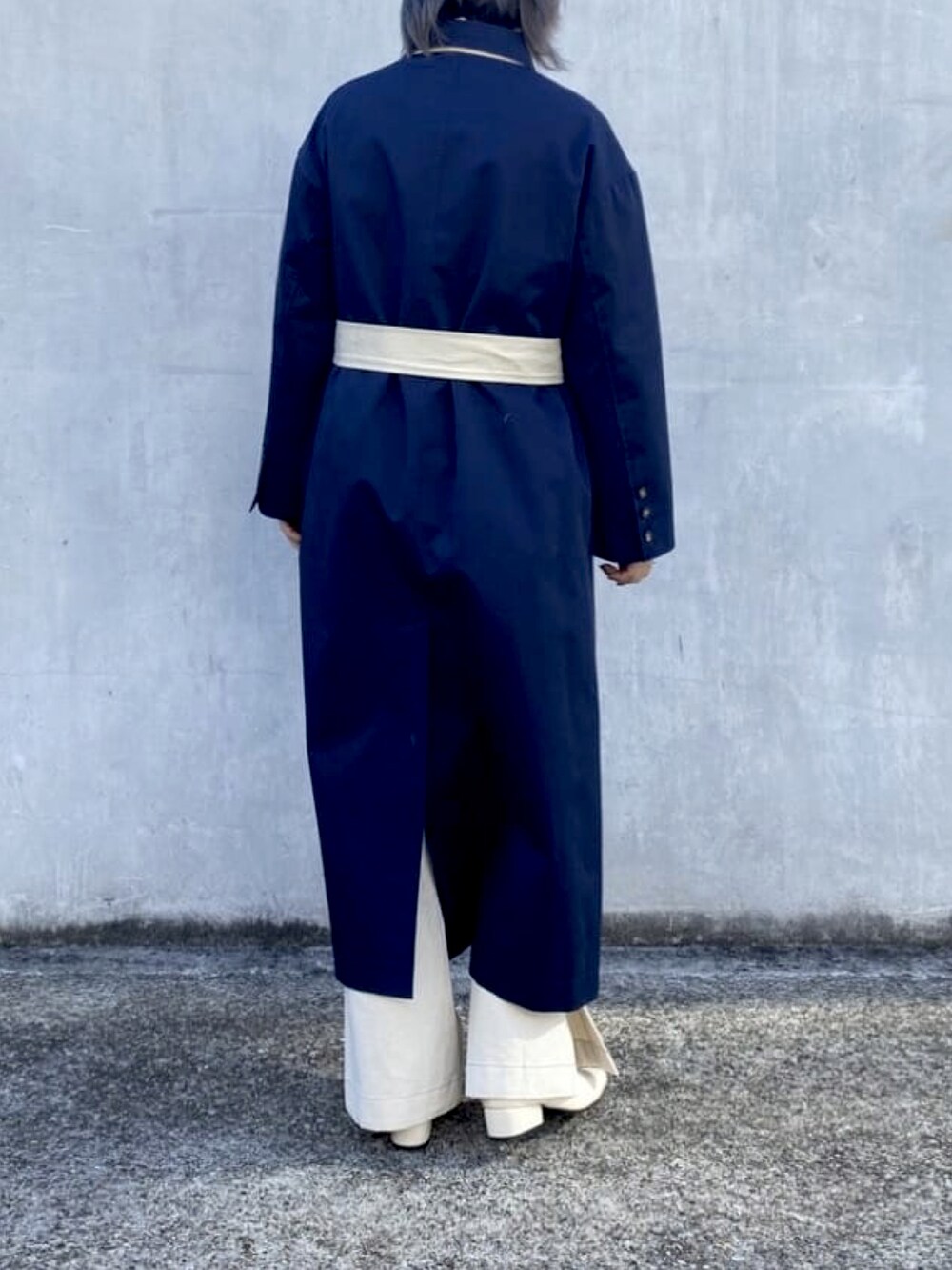 ブルー系のトレンチコート、ホワイト系のデニムパンツ、ホワイト系のブーツを着用したレディースの冬コーディネートの2枚目の写真