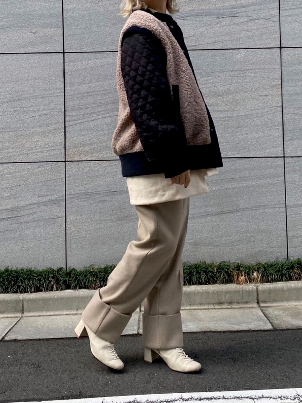 ブラウン系のブルゾン、ホワイト系のスウェット、ベージュ系のその他パンツを着用したレディースの冬コーディネートの3枚目の写真